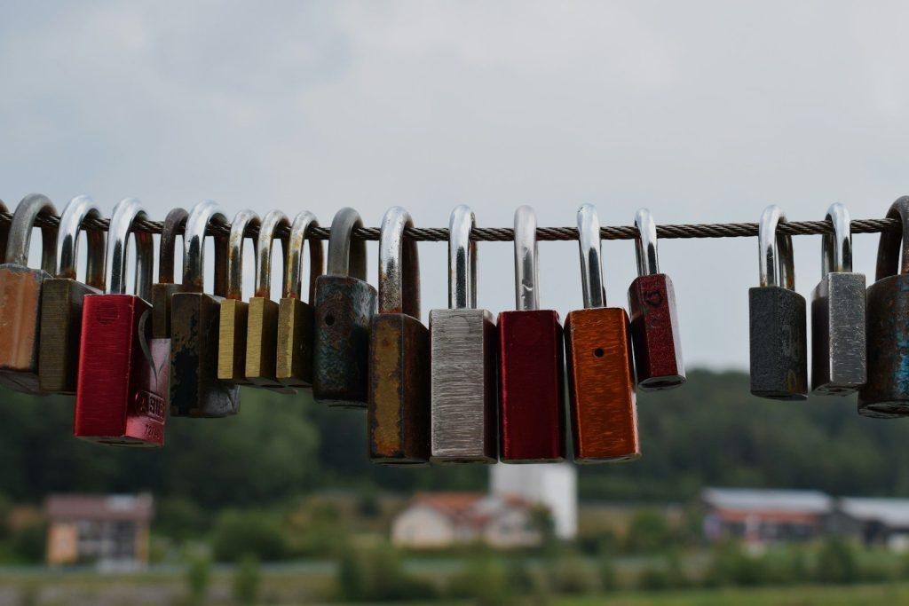 red and brown padlock on gray metal wire