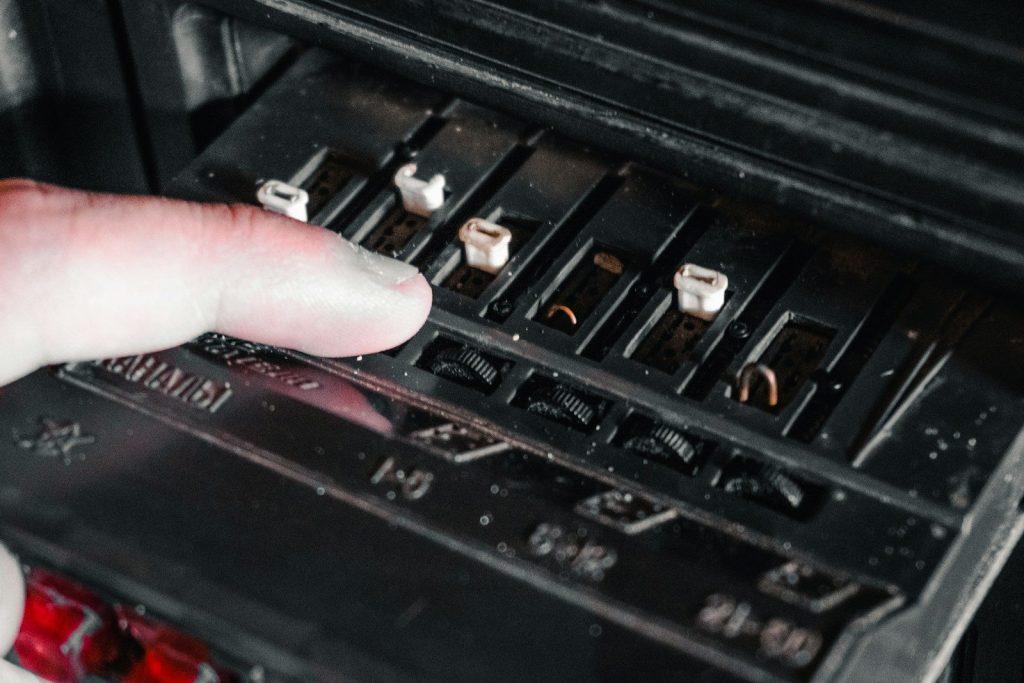Finger adjusting sliders on vintage audio equipment.
